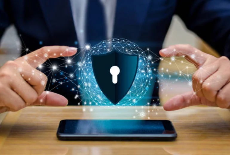 An individual shows a mobile device and a sign that says, Protect your company from online threats.