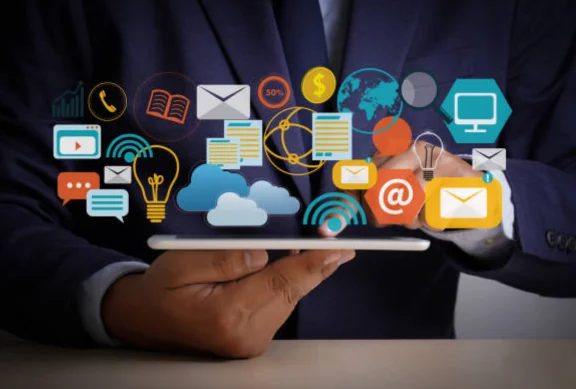 A person typing on a laptop with icons from the screen, representing top consultant service